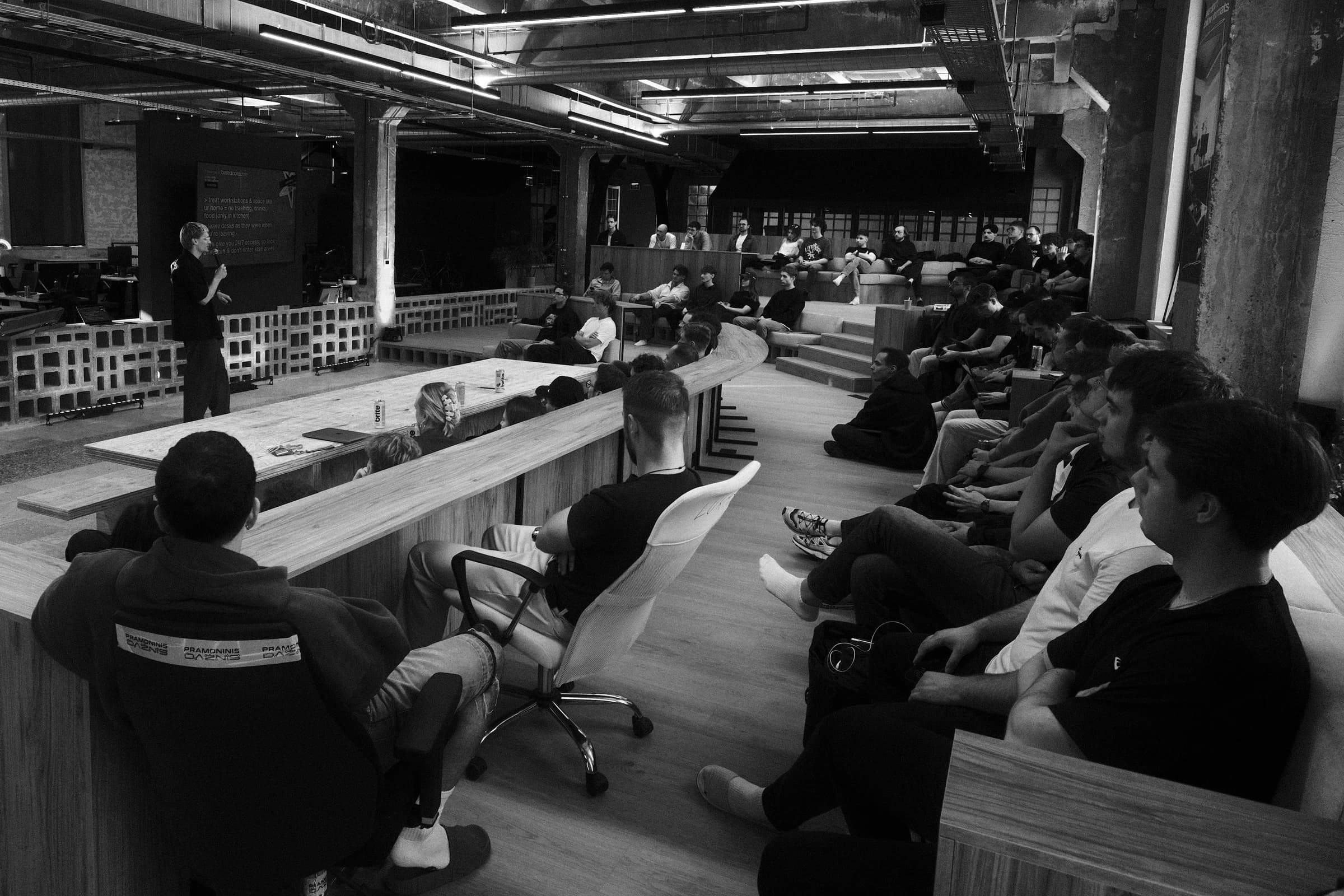 basedhq vilnius, the tech zity floor mid talk, around thirty founders seated along the long plywood table and up the steps under a bare concrete ceiling